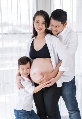 mutlu aile kavramı, hamile anne, baba ve oğul sarılma