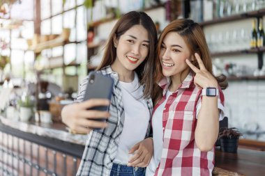 iki neşeli kadın alarak selfie bir smartphone cep telefonu ile