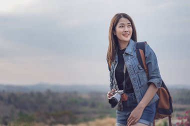 sırt çantası ve kırsal kesimde kamera ile kadın turist