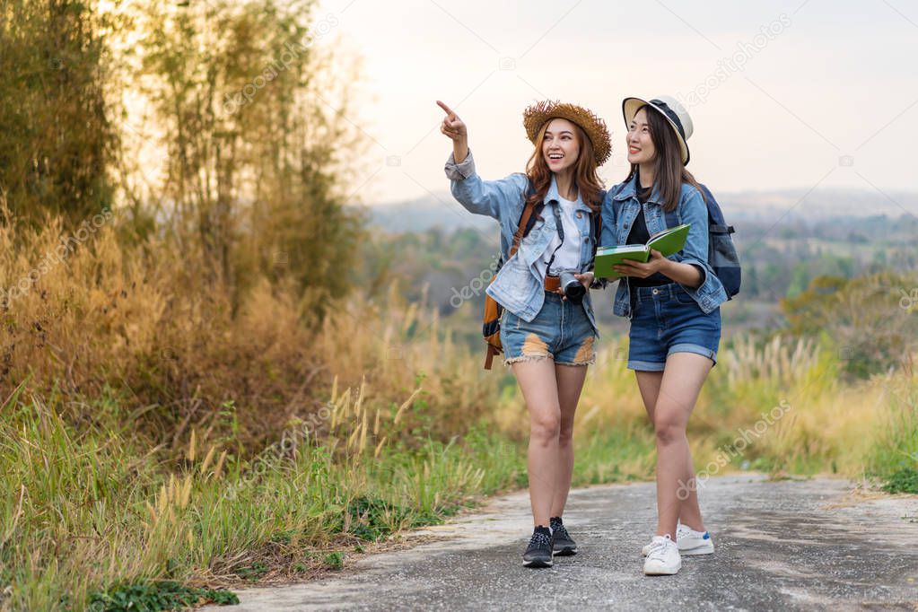 two woman traveler searching direction on location map while traveling 