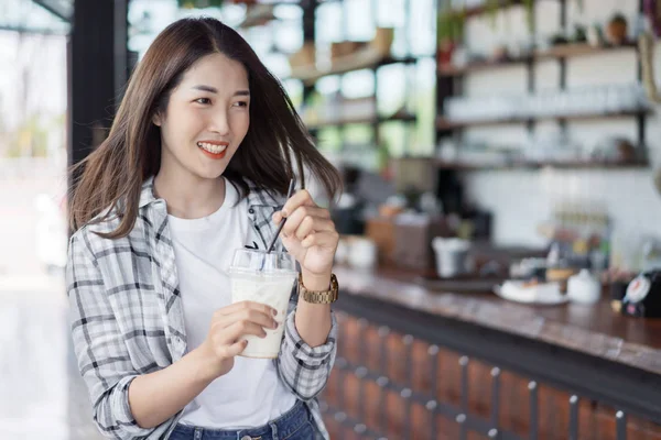 Женщина, держащая стакан холодного молока в кафе — стоковое фото