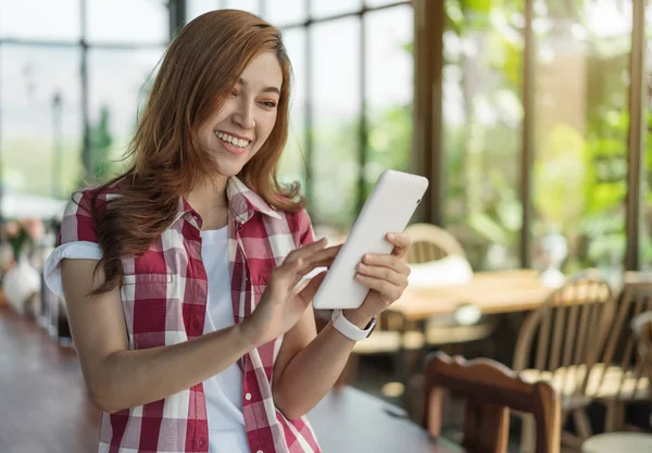 Счастливая женщина с помощью цифрового планшета в кафе — стоковое фото