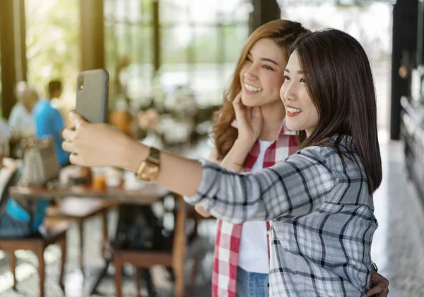 Zwei fröhliche Frauen machen Selfie mit dem Smartphone — Stockfoto