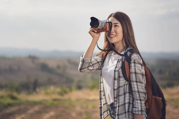 Туристическая женщина фотографируется с камерой на природе — стоковое фото