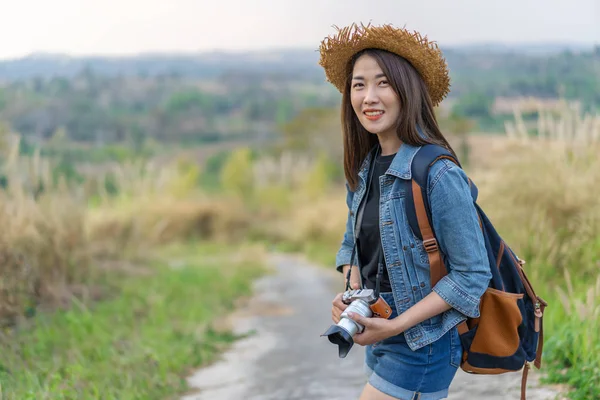 Ženské Turistický batoh a fotoaparát v krajině — Stock fotografie