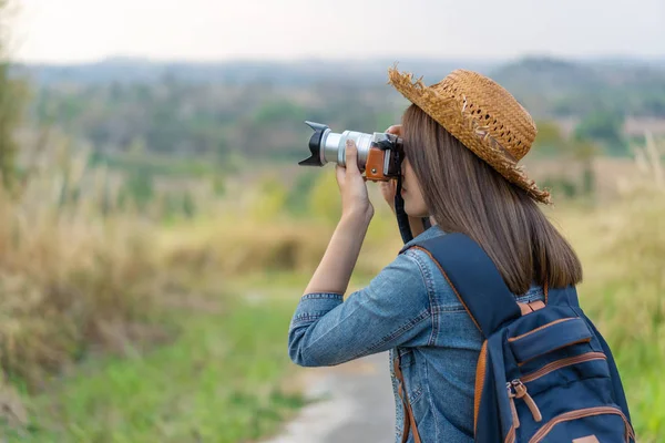 Toeristische vrouw nemen foto met haar camera in de natuur — Stockfoto