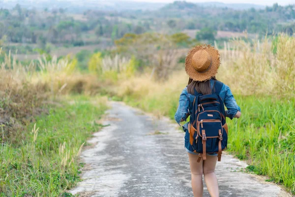 Woman with backpack walking on footpath in nature — Stock Photo, Image