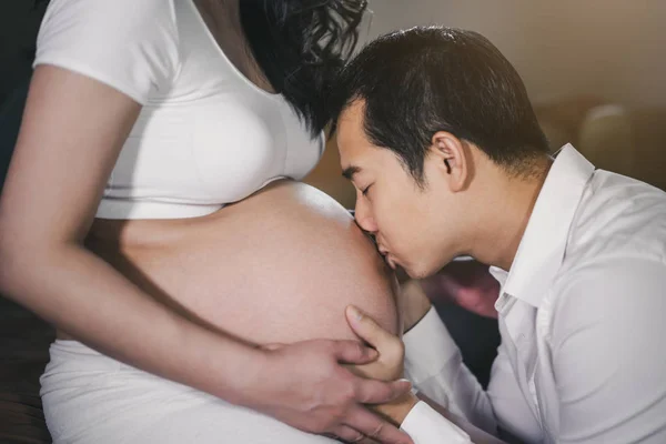 Husband kissing to his wife's belly — Stock Photo, Image