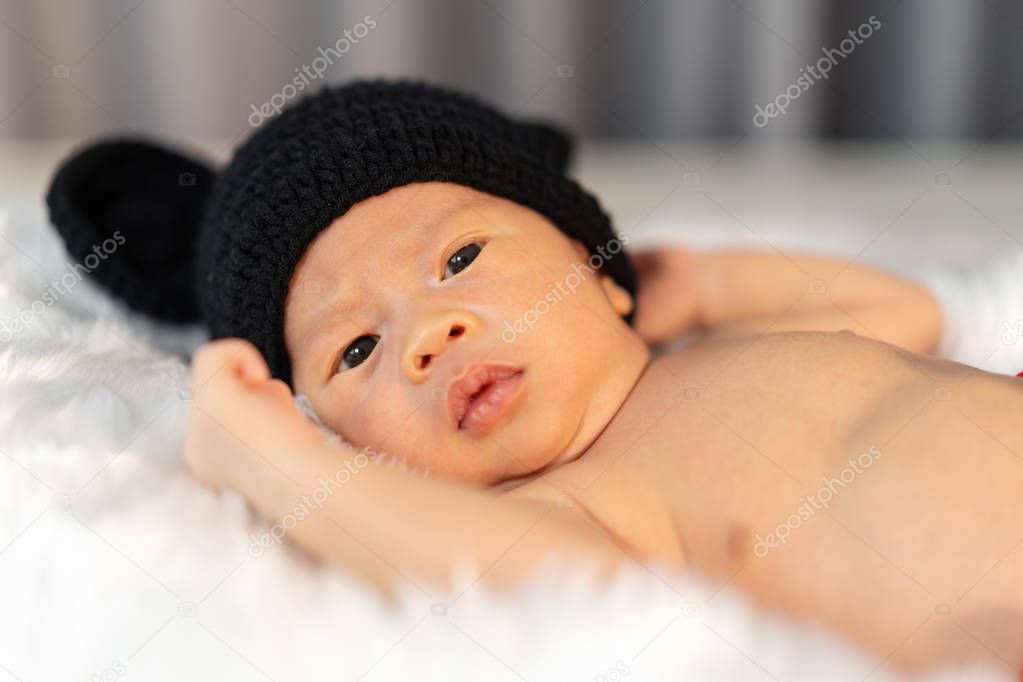 newborn baby in mouse costume on fur bed