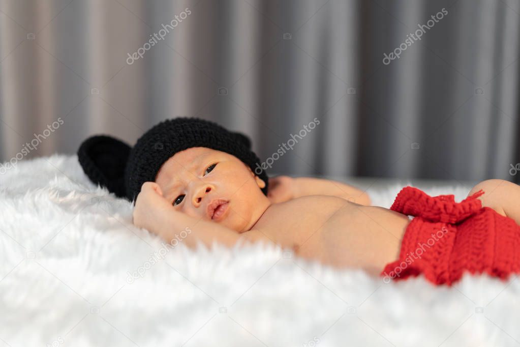 newborn baby in mouse costume on fur bed