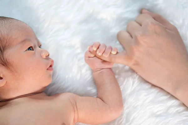 신생아 아기 어머니의 손의 새끼 손가락을 들고 — 스톡 사진