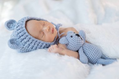 Yeni doğan bebek kürk yatakta uyuyan ayı şapkalı