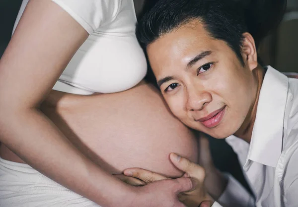 Esposo escuchando el vientre de su esposa — Foto de Stock