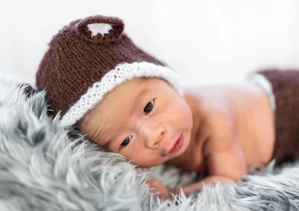 Newborn baby in bear hat on fur bed — Stock Photo, Image