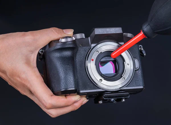 hand using air blower to cleaning dust on camera sensor