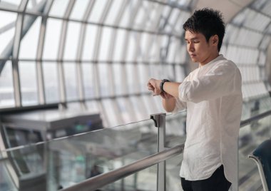 uçuş bekleyen adam ve havaalanında akıllı saat arıyor