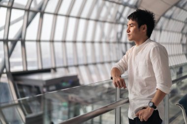 Havaalanında bekleyen bir adam var.