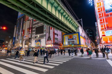 unidendified insanlar gece Akihabara caddenin karşısında yürümek