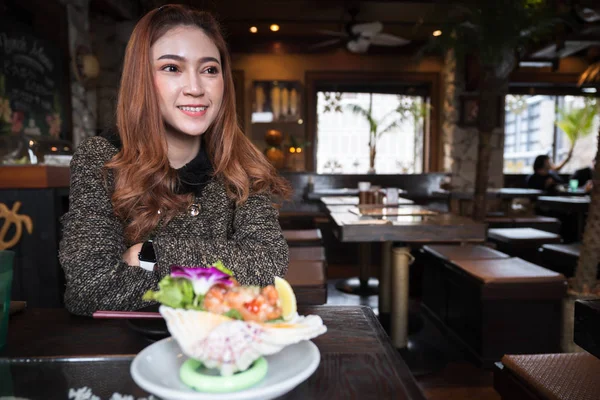 Donna che mangia salmone sashimi insalata piccante nel ristorante — Foto Stock