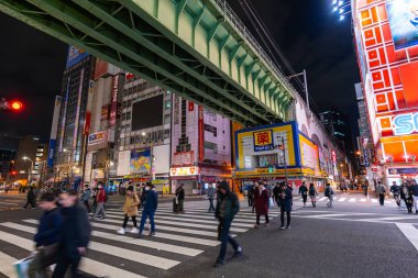 unidendified insanlar gece Akihabara caddenin karşısında yürümek