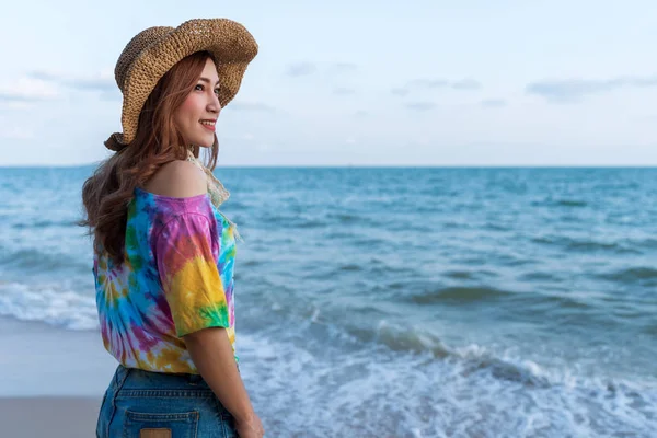 Mujer usando sombrero de pie en la playa del mar — Foto de Stock
