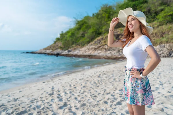 Mulher usando chapéu de pé na praia do mar — Fotografia de Stock