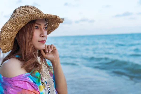 Femme portant un chapeau debout sur la plage de la mer — Photo