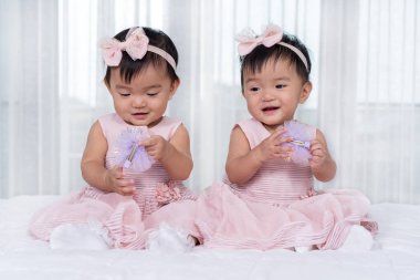 yatakta pembe elbise iki ikiz bebekler