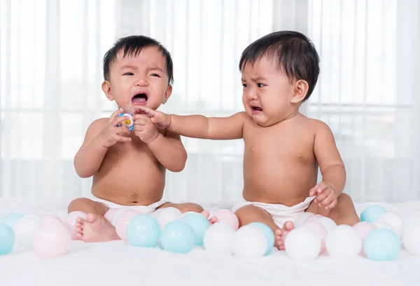 Due bambini gemelli che piangono sul letto — Foto Stock