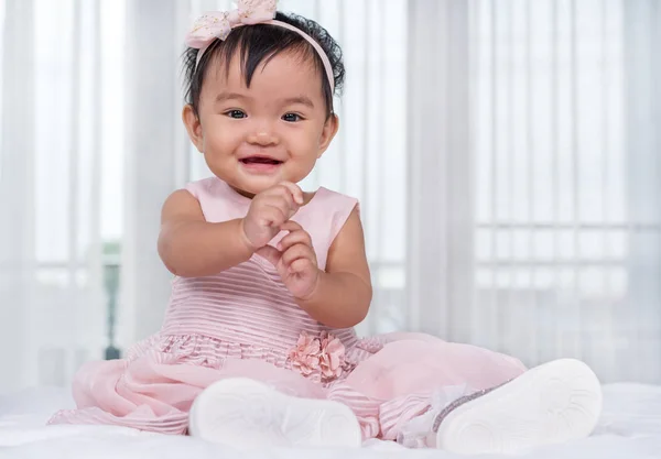 침대에 분홍색 드레스에 아기 — 스톡 사진
