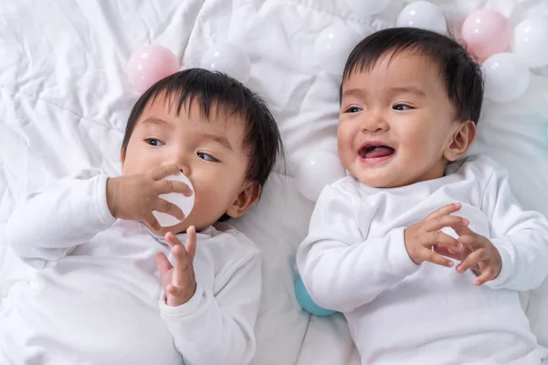 Vrolijke tweeling baby's spelen kleur bal op bed — Stockfoto