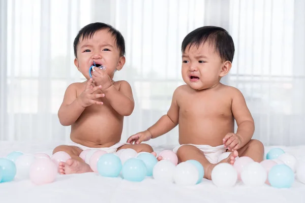 침대에서 울고있는 두 쌍둥이 아기 — 스톡 사진
