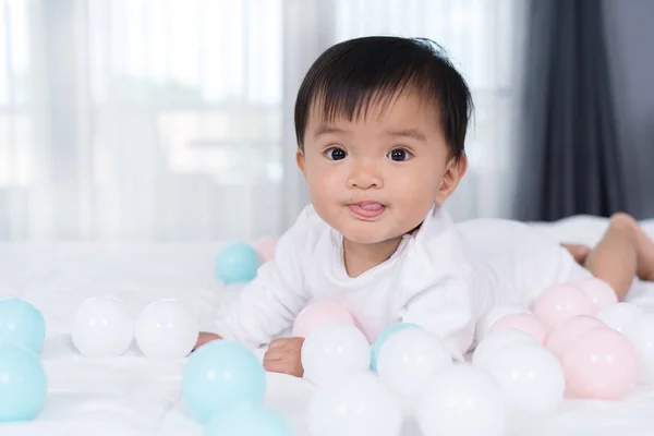 Vrolijke baby spelen kleur bal op bed — Stockfoto