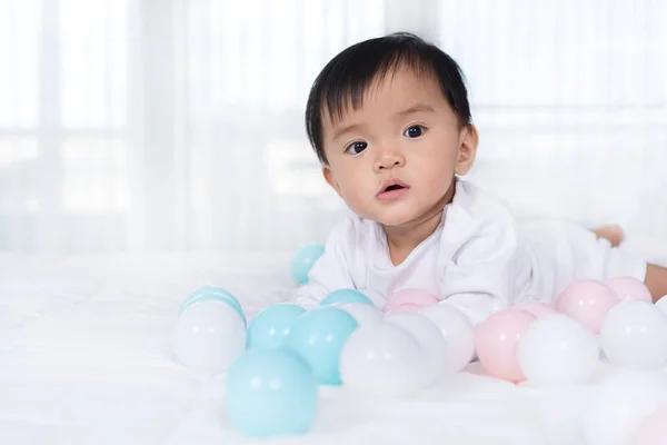 Vrolijke baby spelen kleur bal op bed — Stockfoto