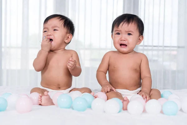 Two twin babies crying on bed — Stock Photo, Image