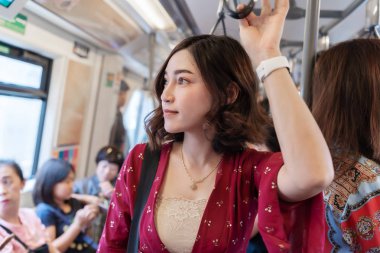 Bandkok kalabalık trende duran korkuluk tutan kadın,