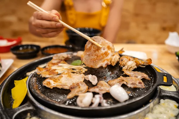 Hände mit Essstäbchen zum Grillen von Schweinefleisch — Stockfoto