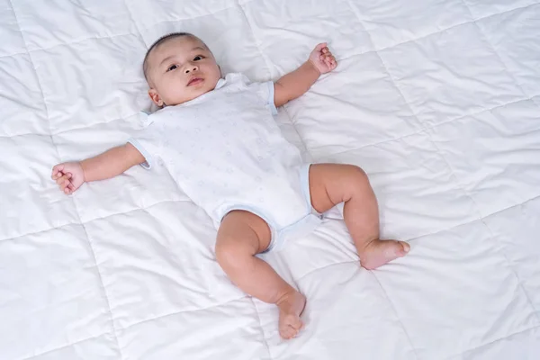 Fröhliches Baby auf einem Bett — Stockfoto