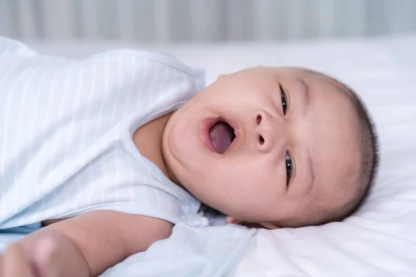 Bostezando bebé en una cama —  Fotos de Stock