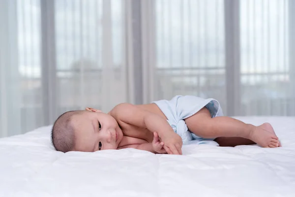 Fröhliches Baby auf einem Bett — Stockfoto