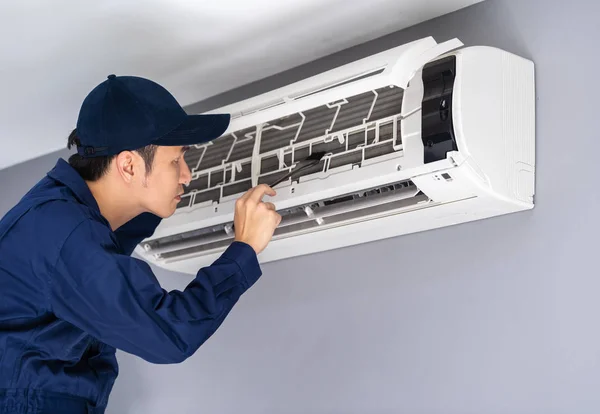 Technicus service met borstel om de airconditioner te reinigen — Stockfoto