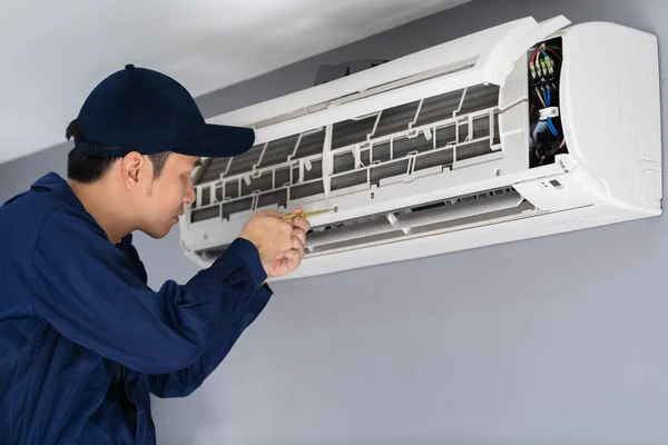 Servicio técnico que utiliza destornillador para reparar aire acondicionado — Foto de Stock