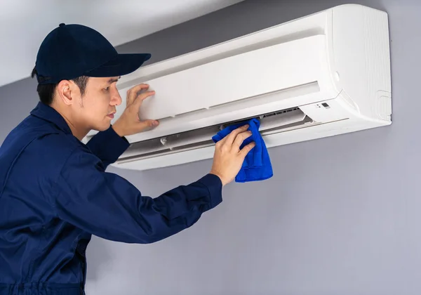 Technicus service schoonmaak airconditioner met doek — Stockfoto