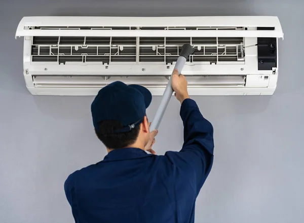Techniker-Service mit Staubsauger zur Reinigung der Klimaanlage — Stockfoto