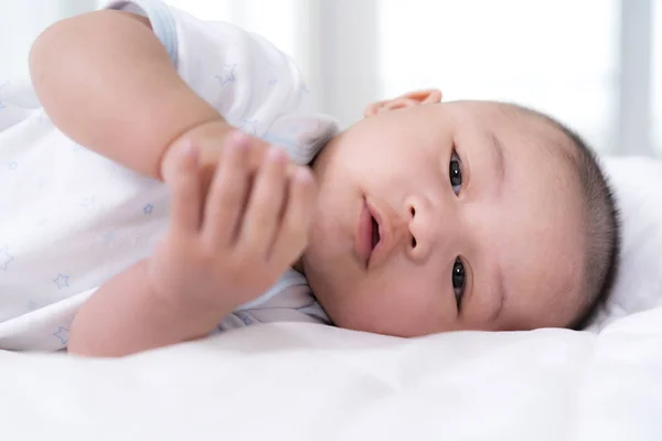 Bebê feliz deitado em uma cama — Fotografia de Stock