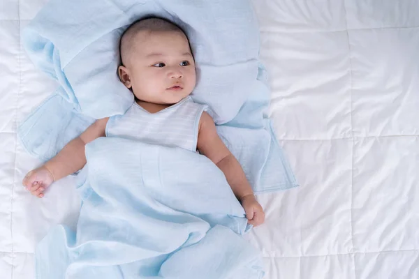 Glückliches Baby auf einem Bett liegend — Stockfoto