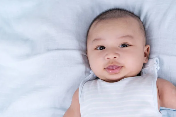 Bebé feliz acostado en una cama —  Fotos de Stock