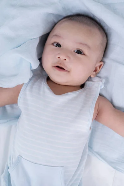 Glückliches Baby auf einem Bett liegend — Stockfoto