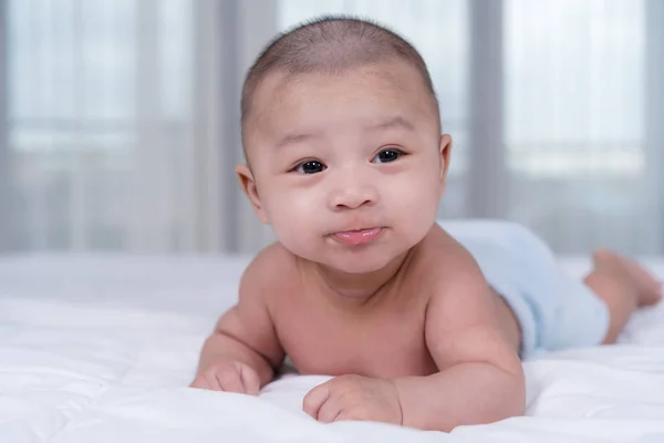 Bebê feliz em uma cama — Fotografia de Stock