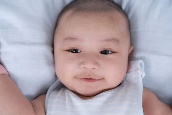 Glückliches Baby auf einem Bett liegend — Stockfoto